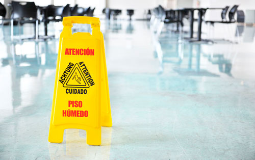 Señal de piso húmedo en oficina